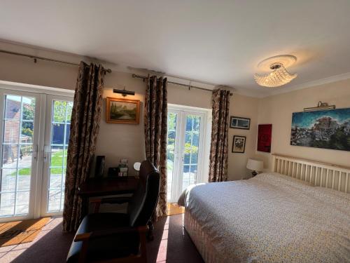 温莎Private Apartment in Windsor的卧室配有一张床、一张书桌和窗户。