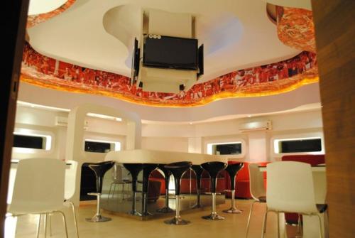 拉特纳吉里Hotel Landmark Ratnagiri的客房设有桌椅和平面电视。