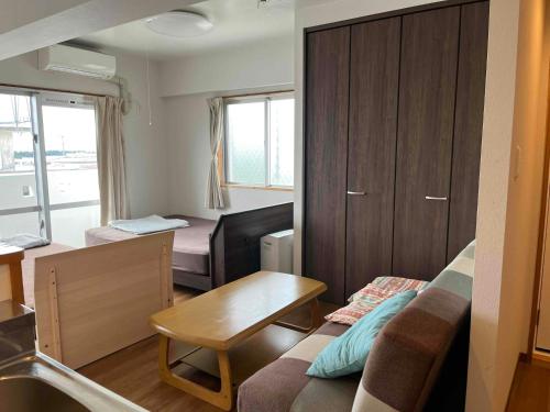 宫古岛Guesthouse Sea Turtle的带沙发和桌子的小客厅