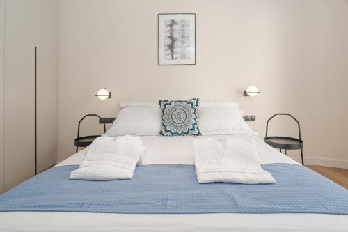 雅典Athens City Chic Apartment-2 bathrooms的一张带蓝色毯子和白色枕头的床