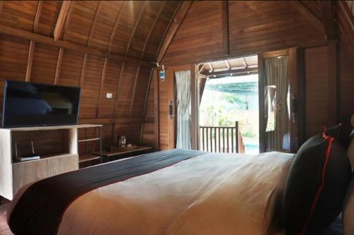 安耶尔Nemuru Villa Ubud Anyer的一间卧室配有一张大床和电视