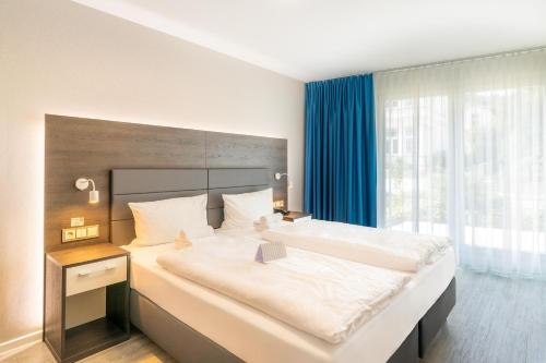 赛巴特班森波罗的海住宅班森斯特尔公寓式酒店的一间卧室设有一张大床和大窗户