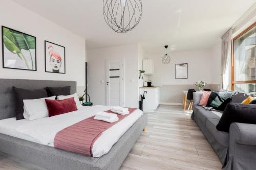 格但斯克Palm Aparts Gdańsk的一间卧室配有一张大床和一张沙发