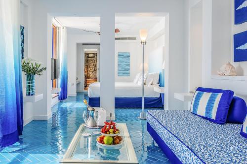 维克艾库塞Capo la Gala Hotel&Wellness的蓝色和白色的客房配有一张床和水果盘