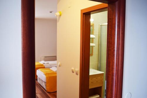 佩斯塔尼Villa Pestani的一间带镜子的浴室和一间带床的卧室
