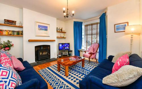 马伯斯Beautiful family home in Mumbles, with garden的客厅设有蓝色的沙发和壁炉