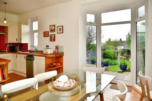 马伯斯Beautiful family home in Mumbles, with garden的厨房以及带玻璃桌的用餐室