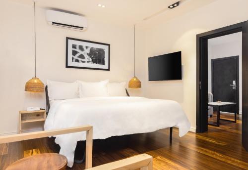 莱基Ulo Lagos的卧室配有一张白色大床和电视。