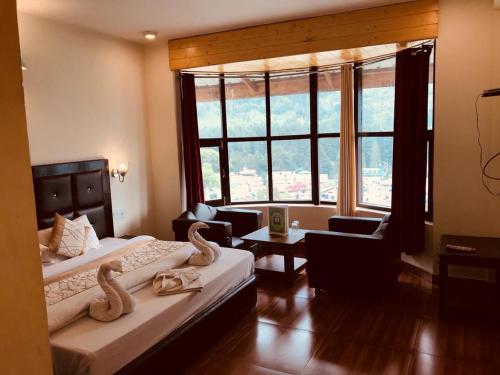 萨哈兰普尔Shunye lodge的酒店客房设有两张床和大窗户。
