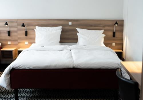 哥本哈根Good Morning City Copenhagen Star的一间卧室配有带白色床单和枕头的床。
