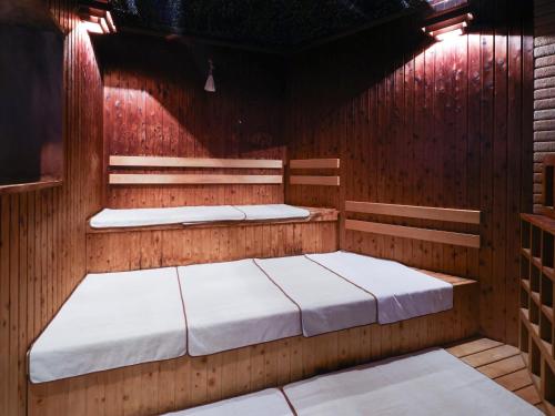 岐阜多美迎岐阜站前酒店的桑拿浴室内的两张床,灯光照亮