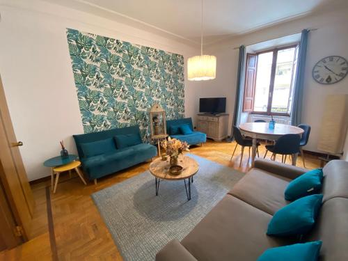 罗马"La Piccola Londra "appartamento a Roma 5 minuti da piazza del Popolo的客厅配有蓝色的沙发和桌子