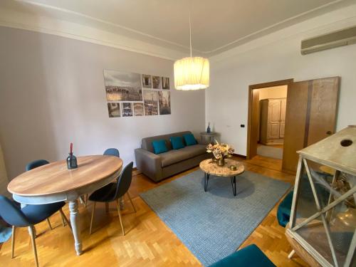 罗马"La Piccola Londra "appartamento a Roma 5 minuti da piazza del Popolo的客厅配有桌子和沙发