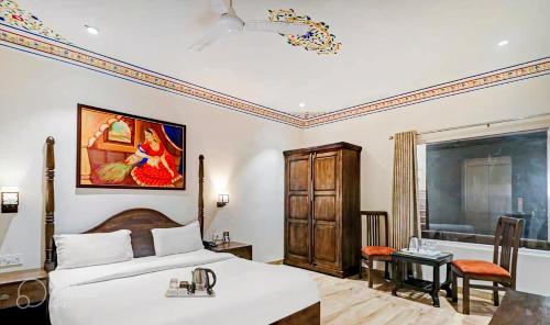阿格拉Hotel Sahibs Royal Ville - Elegance by the Taj的酒店客房设有床、桌子和窗户。