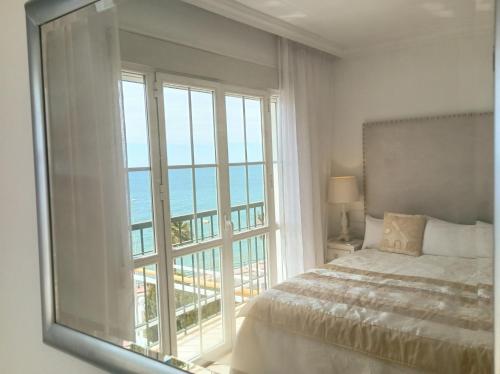 贝纳尔马德纳Townhouse beachfront Benalmadena-Costa的一间卧室设有一张床和一个大窗户