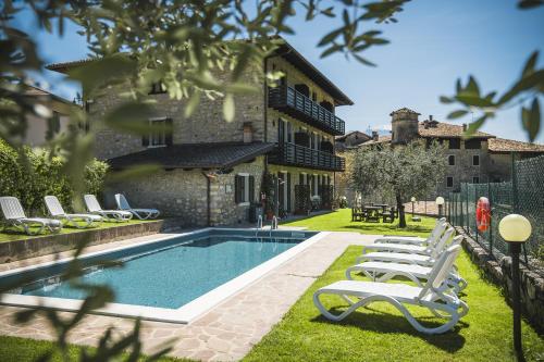 滕诺Hotel Antica Croce - Gardaslowemotion的一座带躺椅的游泳池的房子