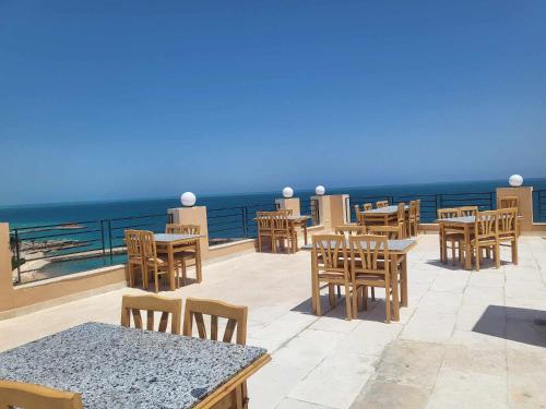赫尔格达SAMA Beach Resort的一个带桌椅的庭院和大海
