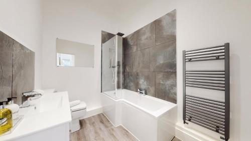 AbertillerySpacious three bedroom apartment with Valley views的白色的浴室设有水槽和卫生间。