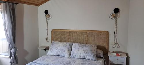 利洛Casa fonte da pena的卧室配有一张床,墙上有两部电话