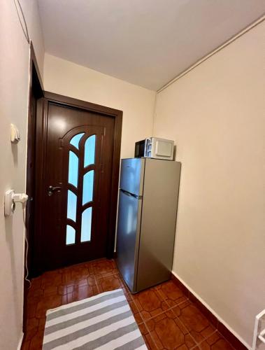 GiurgiuCozy studio flat的带冰箱的厨房和带微波炉的门