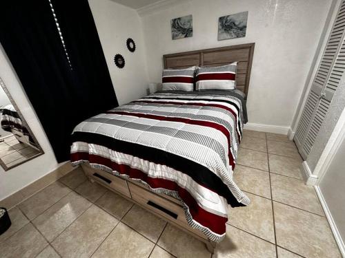 迈阿密花园Miami Breeze Studio的一间卧室配有一张大床、条纹毯子和枕头