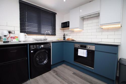 卡迪夫Boutique one bedroom apartment in Cardiff的厨房配有蓝色橱柜和洗碗机。