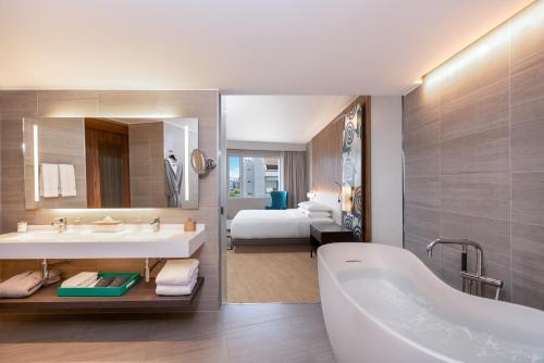 利马Hyatt Centric San Isidro Lima的带浴缸的浴室和1间带1张床的卧室