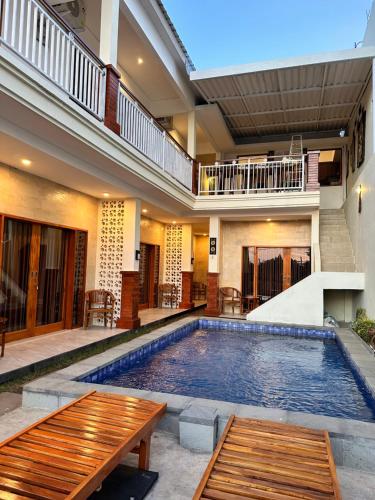 金巴兰Kailash Villa Balangan的一座带两个木长椅的别墅内的游泳池