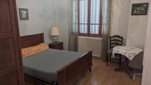 圣让德莫里耶讷Appartement rochenoir的卧室配有床、椅子和窗户。