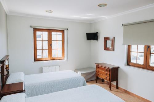 巴尔多维尼奥Casa Veiga的一间卧室设有两张床、一张桌子和窗户。