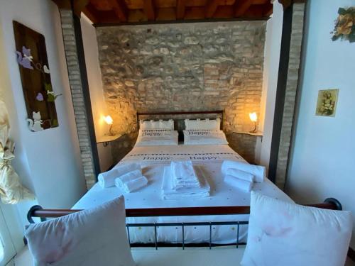 纳托Garda Paradise Country House的一张大床,位于一个石墙房间内