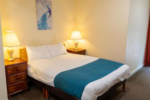 托基特里卡恩酒店的一间卧室配有一张床和两张台灯。