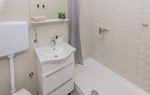 宁Gorgeous Apartment In Nin With Kitchen的白色的浴室设有水槽和淋浴。