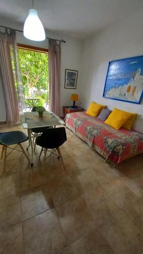 波罗斯poros apartment in garden的一间卧室配有一张床铺和一张桌子,还有一间用餐室