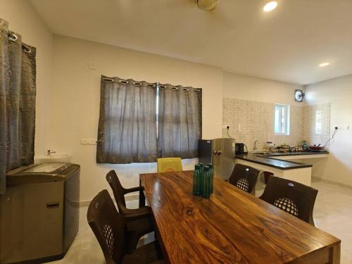 钦奈SAIBALA HOMESTAY - AC 5 BHK NEAR AlRPORT的厨房配有木制餐桌和椅子