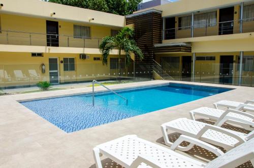 库库塔Hotel Arizona Suites Cúcuta的一座带椅子的游泳池以及一座建筑