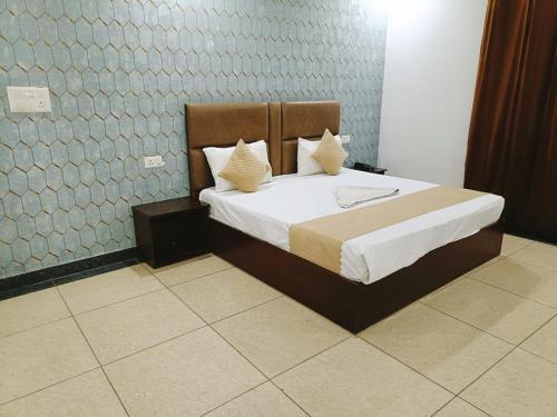 新德里Hotel Ambience Palace Near IGI Airport Delhi的一间卧室配有带白色床单和枕头的床。