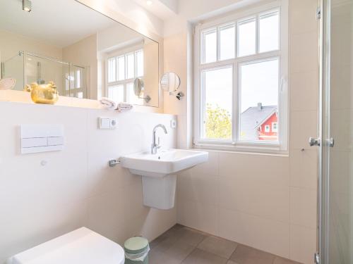 欧巴德伍斯图Haus STRANDLUST WF-05的一间带水槽和卫生间的浴室以及窗户。