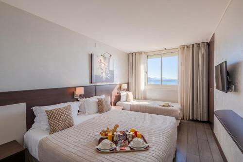 圣马克西姆海滩酒店的一间酒店客房,配有一张床铺,上面放着一个食物托盘