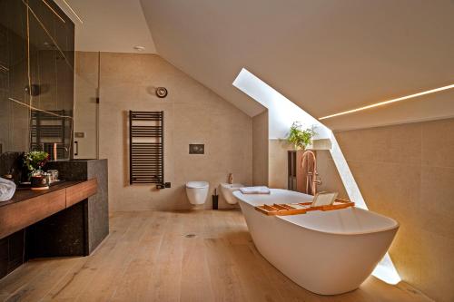 托莱多Hotel Cigarral Santa María的浴室配有大型白色浴缸和水槽