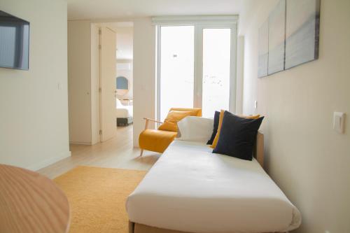 波尔图room Select Porto Suites的配有床和橙色椅子的房间