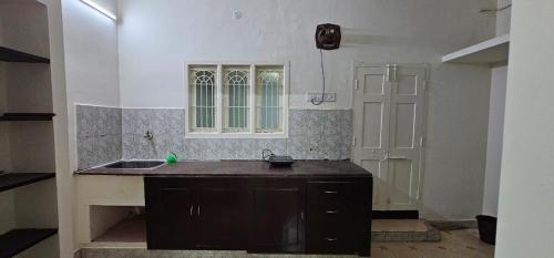 钦奈SAIBALA HOMESTAY - AC 3 BHK NEAR AlRPORT的厨房设有水槽和窗户。