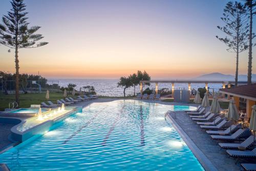 马斯蒂查里Ammos Luxury Resort的一个带躺椅的游泳池和海洋