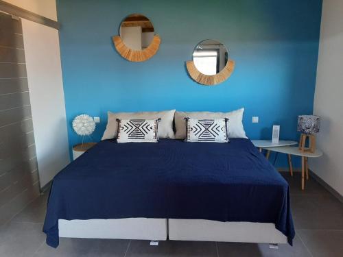 拉波塞雄Bungalow de luxe en bois avec Spa的蓝色的卧室,配有床和蓝色的墙壁