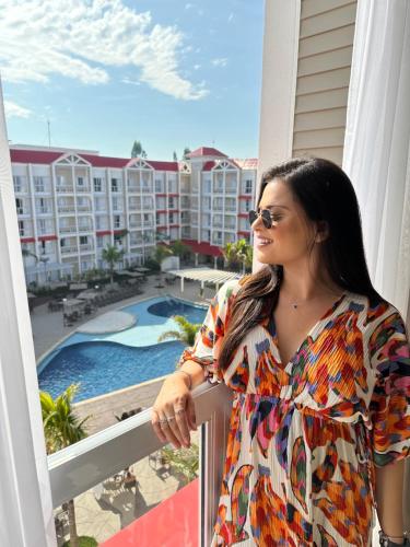 圣代佩德罗São Pedro Thermas Resort Oficial的站在阳台的女人,看着泳池