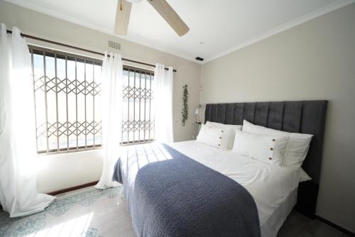 开普敦The Dahlia的一间卧室设有一张大床和大窗户