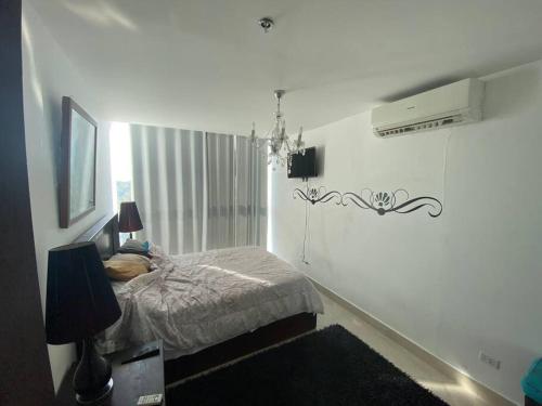 La ChumicosaPh Ibiza Playa Corona的白色卧室配有一张床和一个吊灯