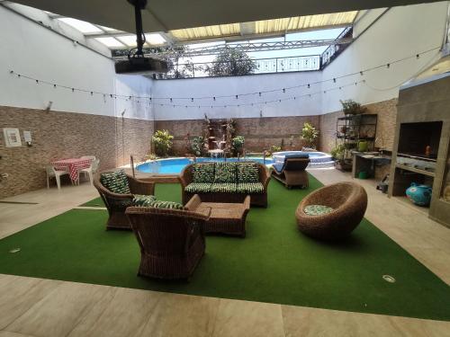 布卡拉曼加Encantadora Casa, Ubicación Ideal en Bucaramanga的一个带椅子的客厅和一个游泳池