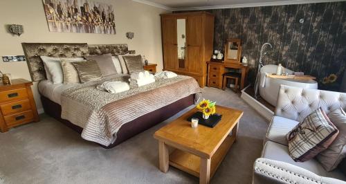 莫法特Black Bull Inn, Moffat的一间卧室配有一张床、一个浴缸和一张沙发