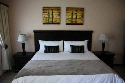 曼齐尼Hotel Tum's Water World的一间卧室配有一张带两盏灯的大型白色床。